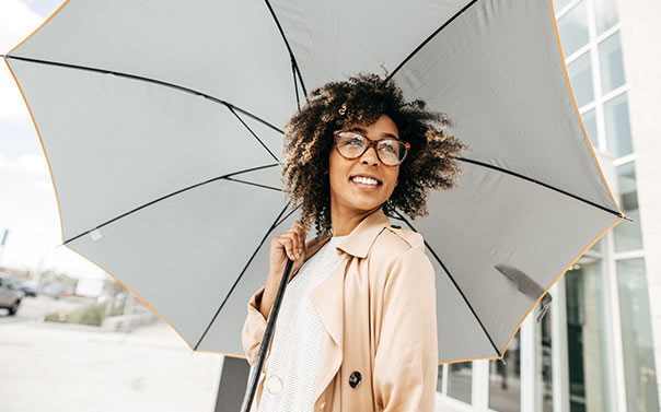 happy woman with umbrella insurance